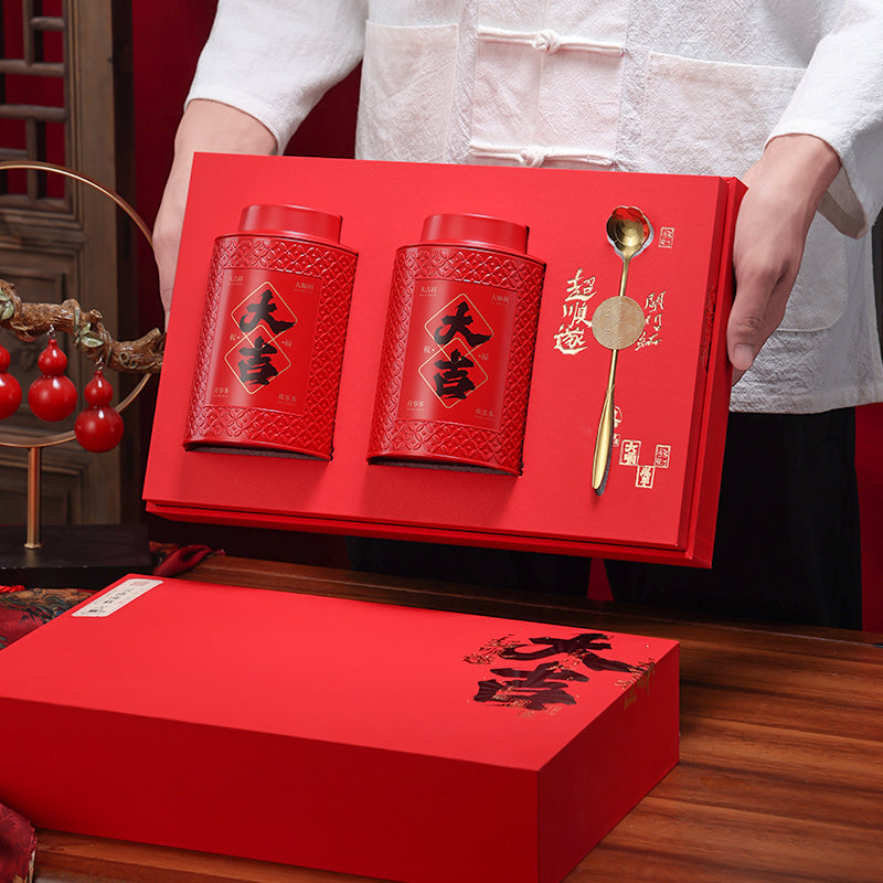 Deluxe Yunnan Dian Hong black tea gift set with two red patterned tea tins and a golden tea scoop, presented in an elegant red gift box with Chinese calligraphy. Perfect for gifting premium Chinese black tea on festivals and special occasions.
