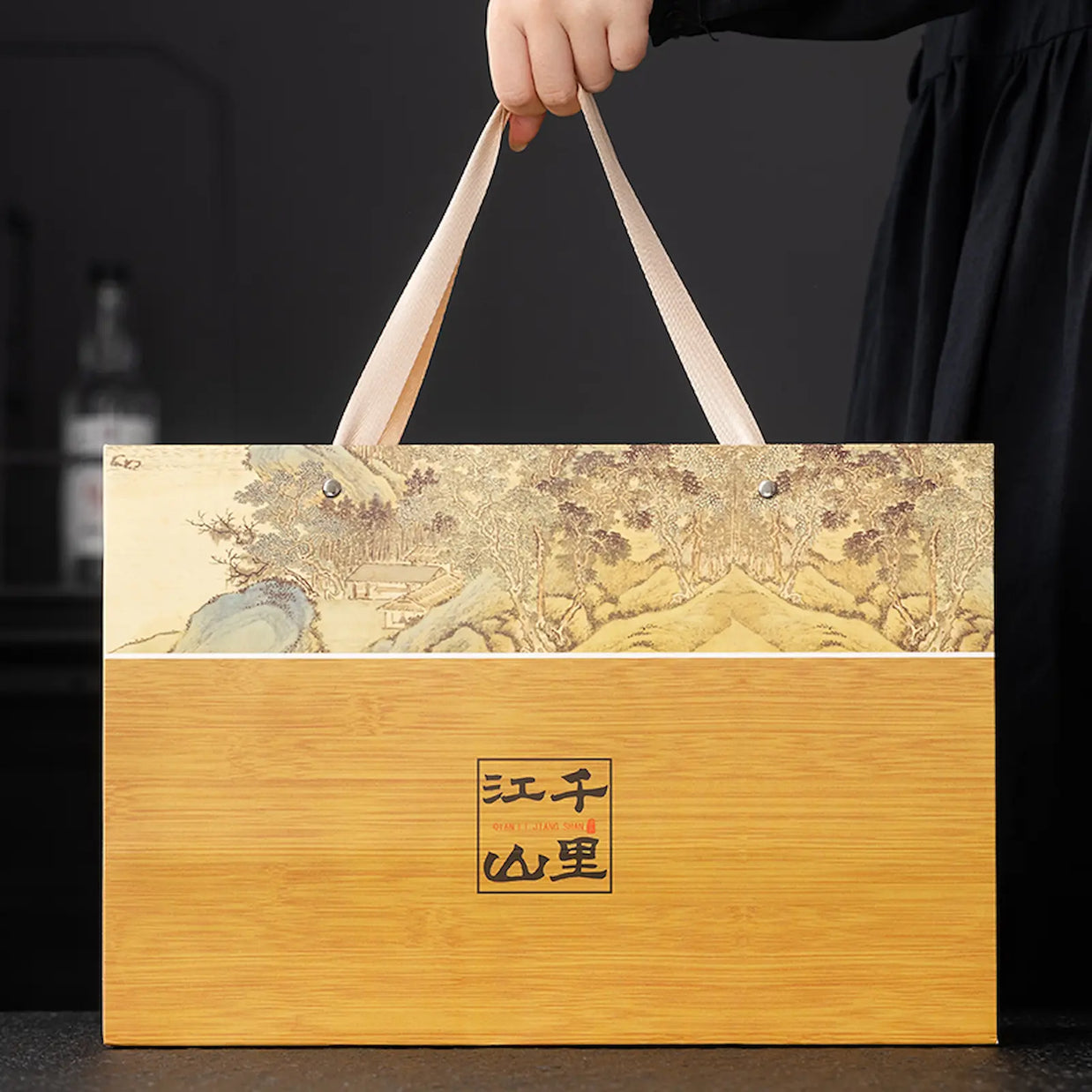Elegant bamboo-style West Lake Longjing green tea gift bag with traditional Chinese landscape painting and sturdy handles, perfect for presenting premium Xi Hu Dragon Well tea on holidays and special occasions.
