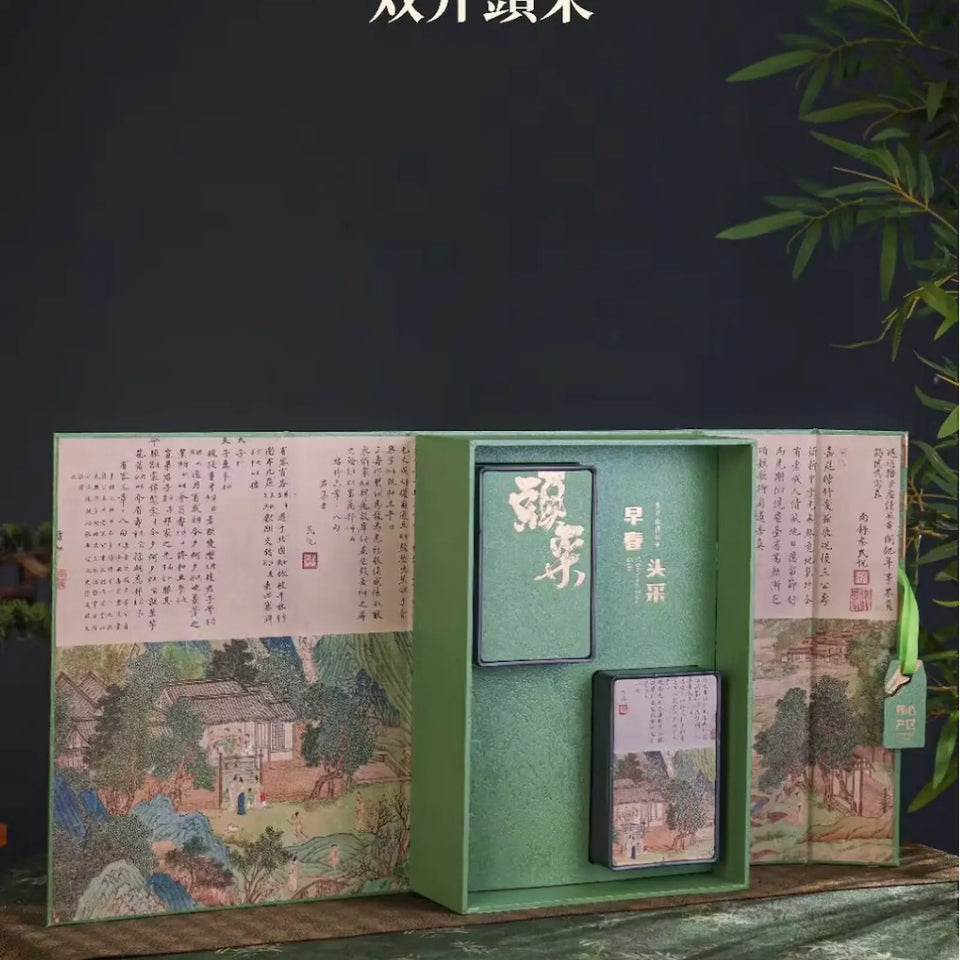 Exquisite Ming Qian Longjing green tea gift box featuring elegant Chinese landscape painting and calligraphy, with premium tea tins nestled inside. Perfect presentation for authentic pre-Qingming West Lake Dragon Well tea.
