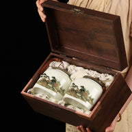 Luxury Bi Luo Chun green tea gift set with two ceramic jars featuring traditional Chinese landscape paintings, presented in an elegant wooden box. Perfect premium tea gift for special occasions or tea collectors.

