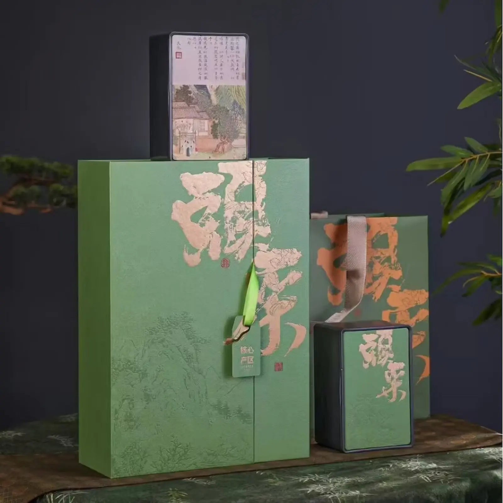 Premium Ming Qian Longjing green tea gift set featuring elegant green packaging with gold Chinese calligraphy, including a gift bag, tea gift box, and sealed tea tin. Perfect for presenting authentic pre-Qingming West Lake Dragon Well tea on special occasions.
